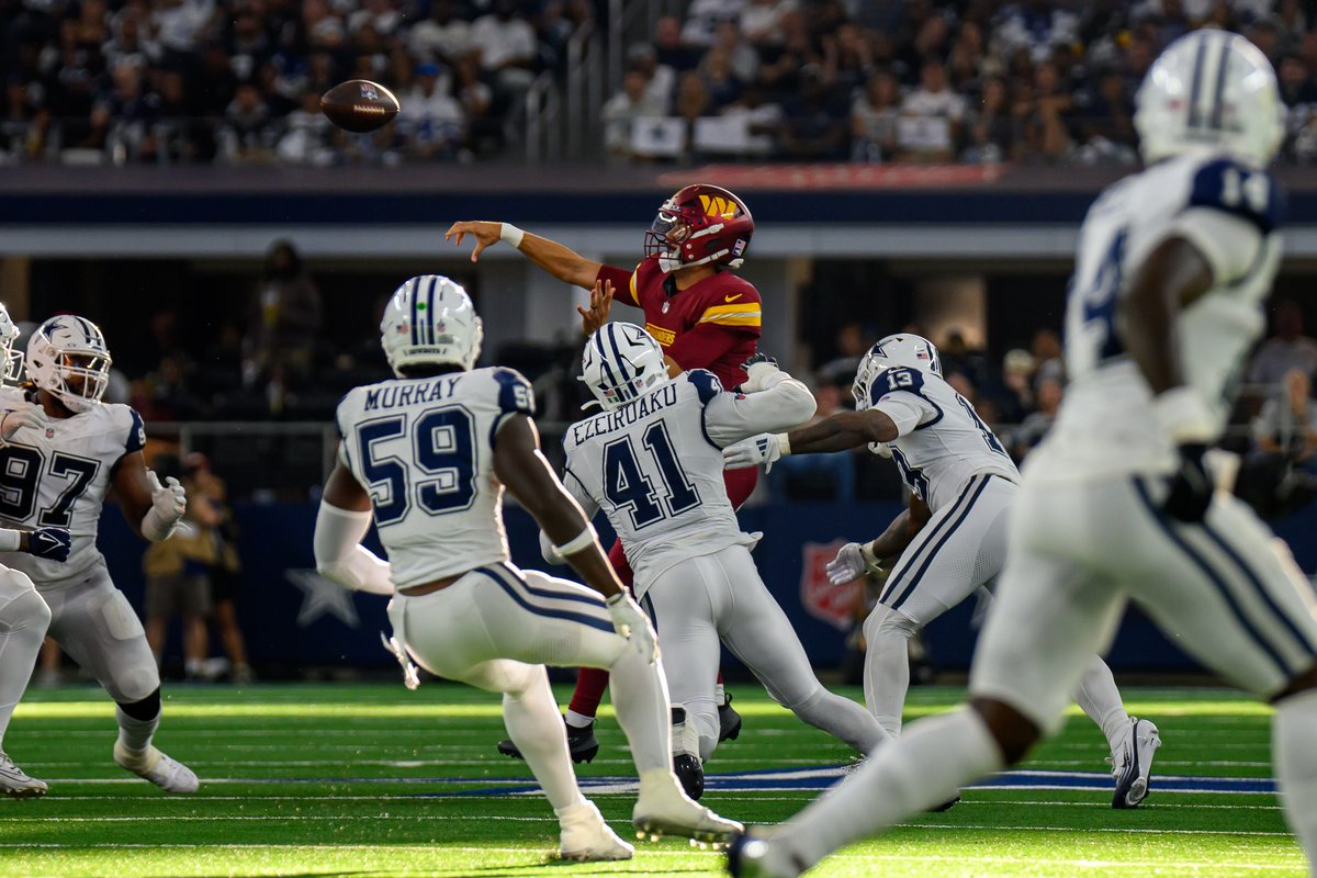 Dallas Cowboys defenders in white home jerseys at AT&T Stadium during a 2025 game against the Washington Commanders