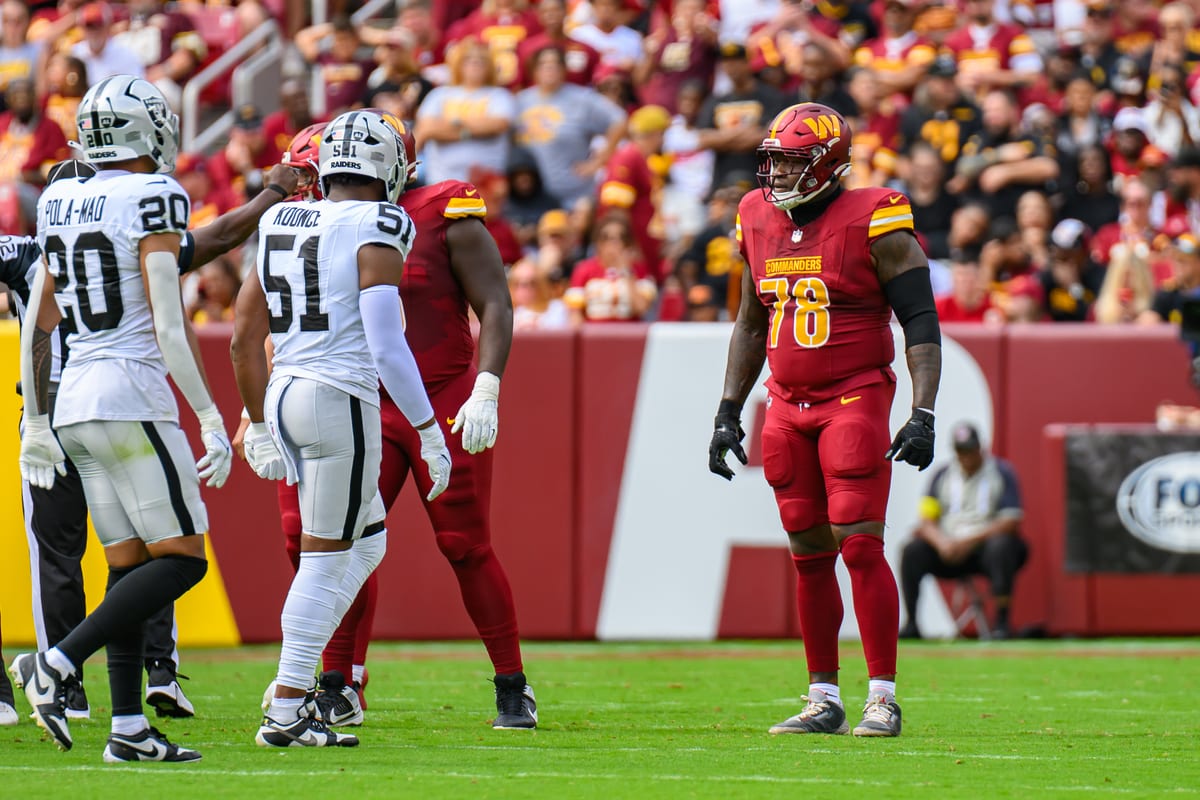 Raiders defenders in the white road uniform and silver helmets against the Commanders in 2025