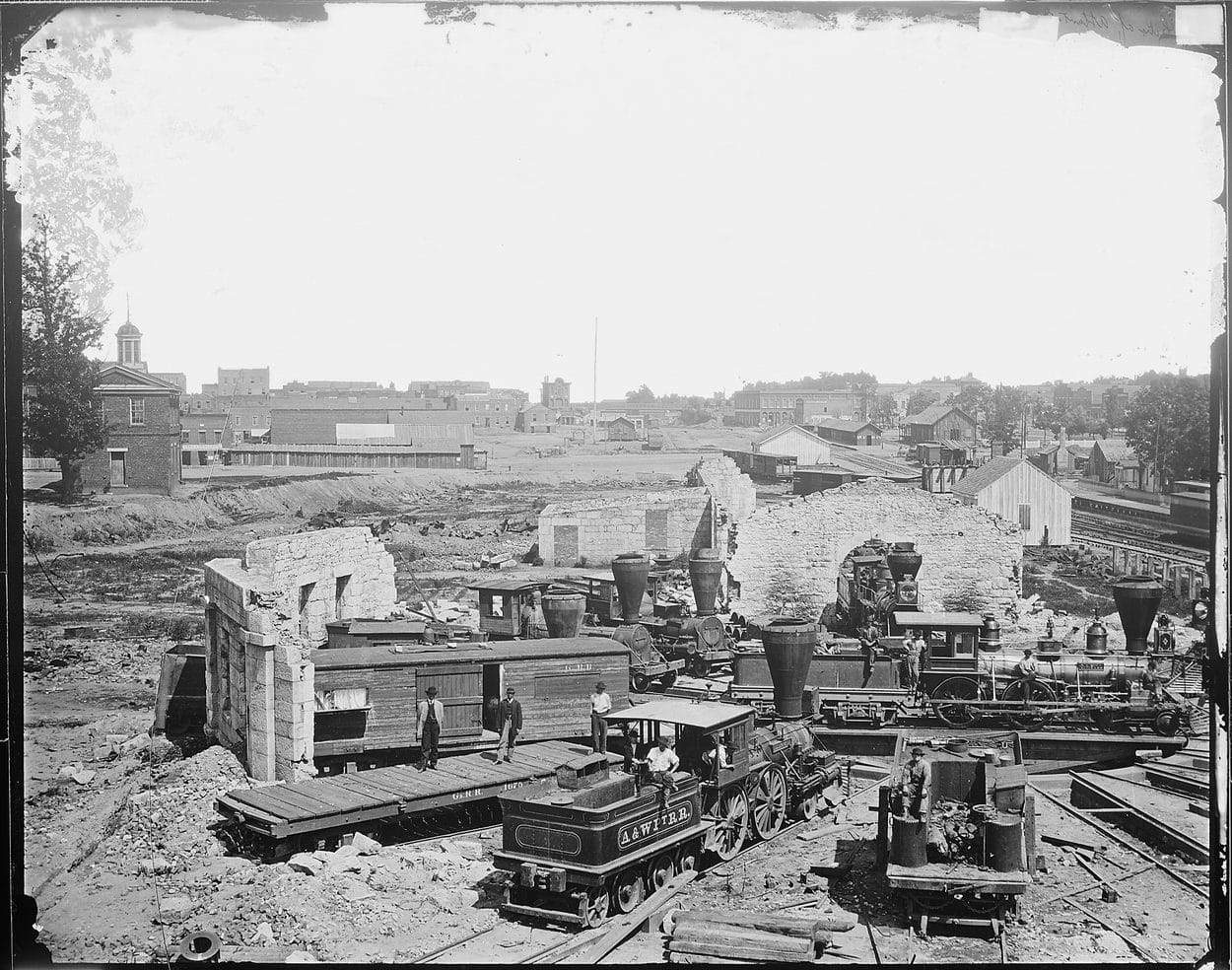 The ruins of Atlanta's rail yard after Sherman's forces burned the city in 1864, wrecked locomotives and depot walls among the rubble
