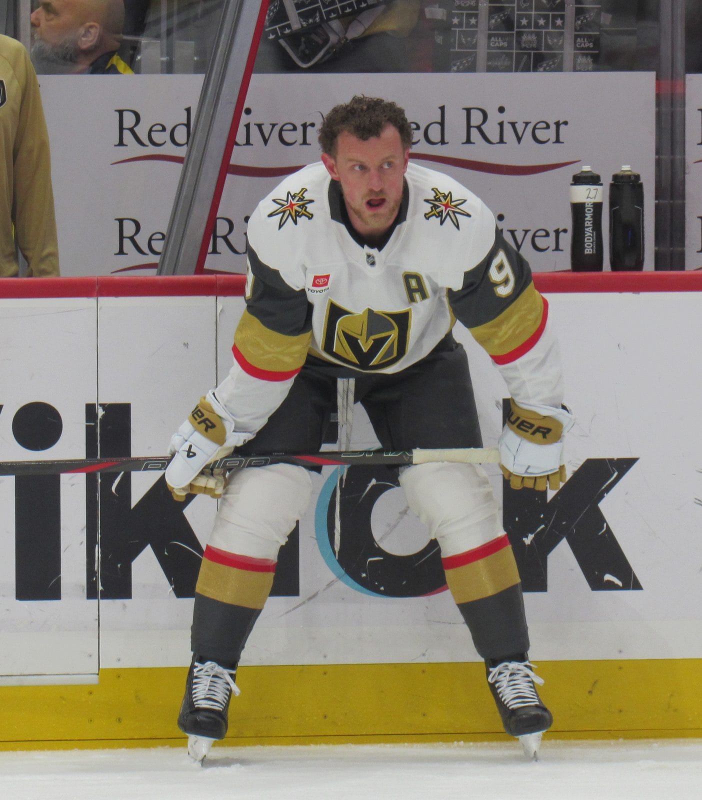 Jack Eichel, wearing an A, in the Golden Knights' white road uniform with the knight-helmet V crest and gold and gray stripes, No. 9, during warmups at Capital One Arena in Washington, February 27, 2026