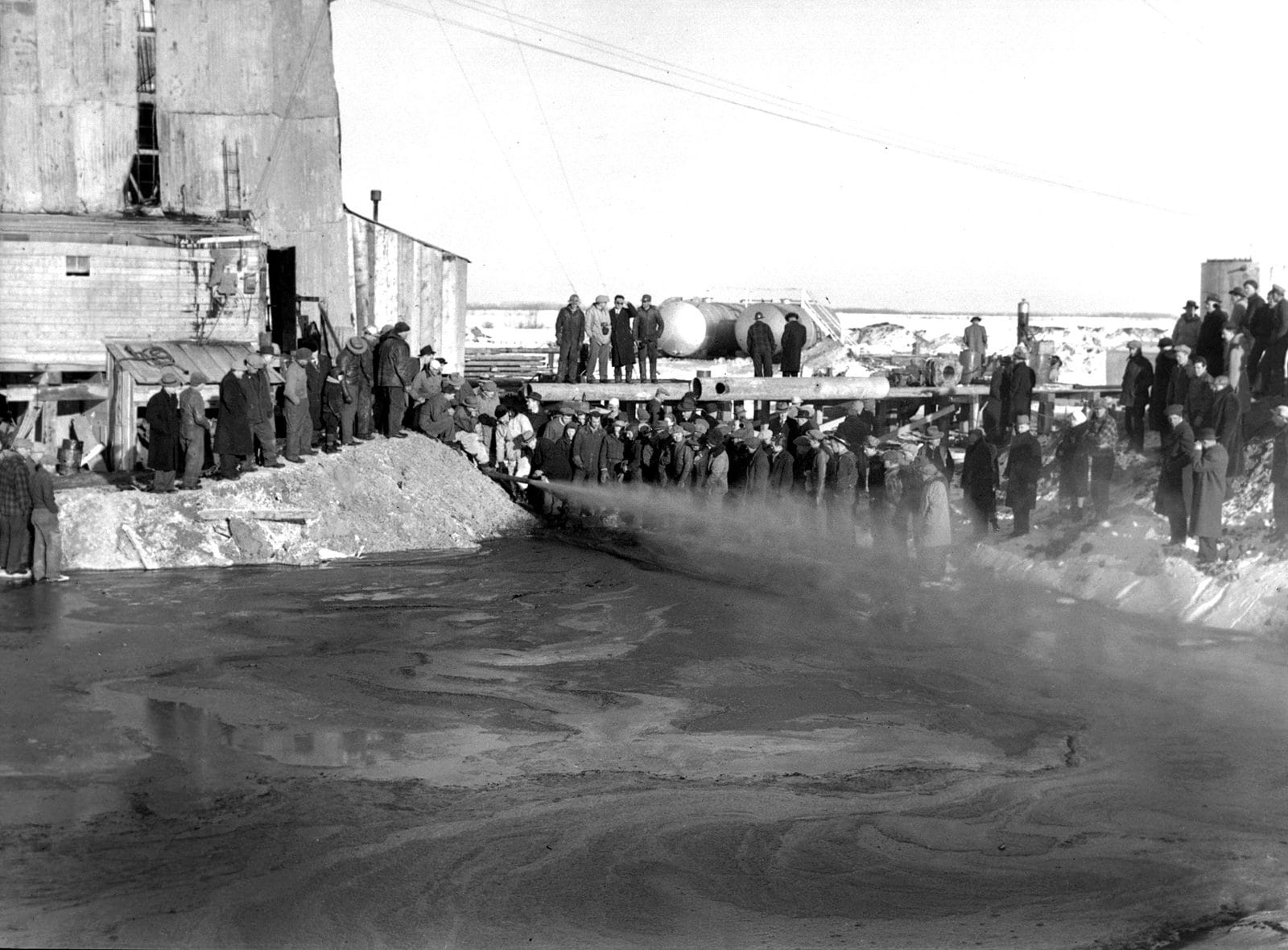 Crowds watch the Imperial Leduc No. 1 oil well near Edmonton flare on February 13, 1947, the strike that launched Alberta's oil boom
