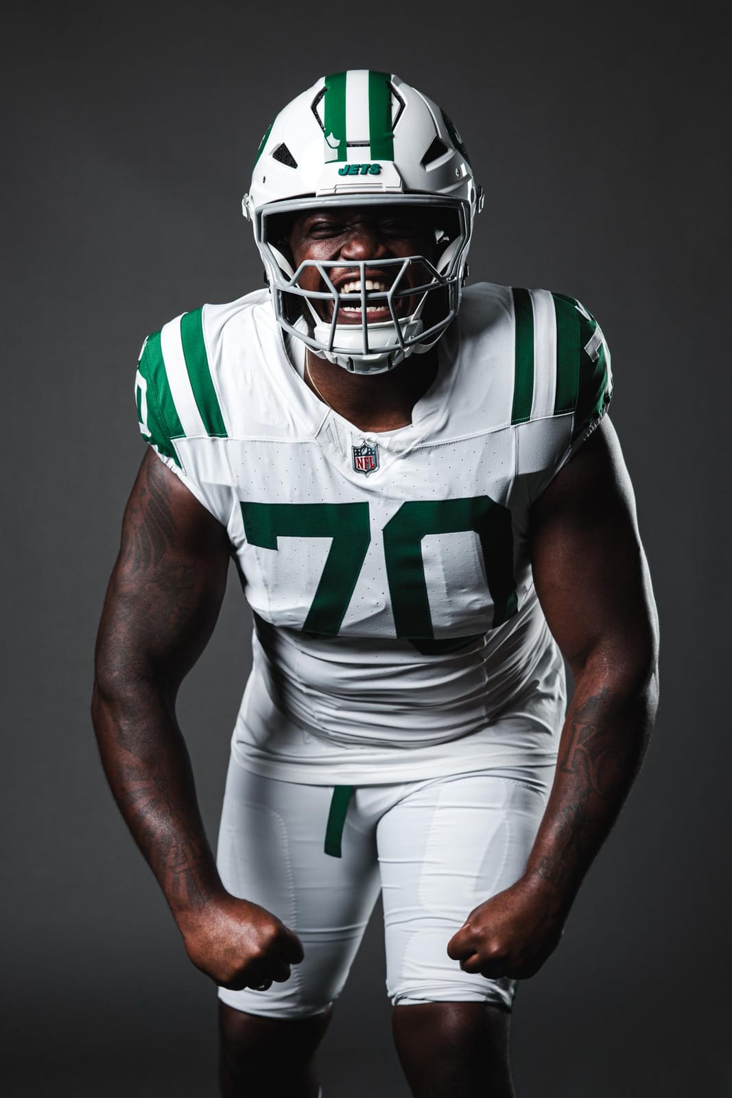 Jets offensive lineman in the Classic throwback uniform: white helmet with green stripes and gray facemask, white jersey number 70 with green sleeve stripes, white pants