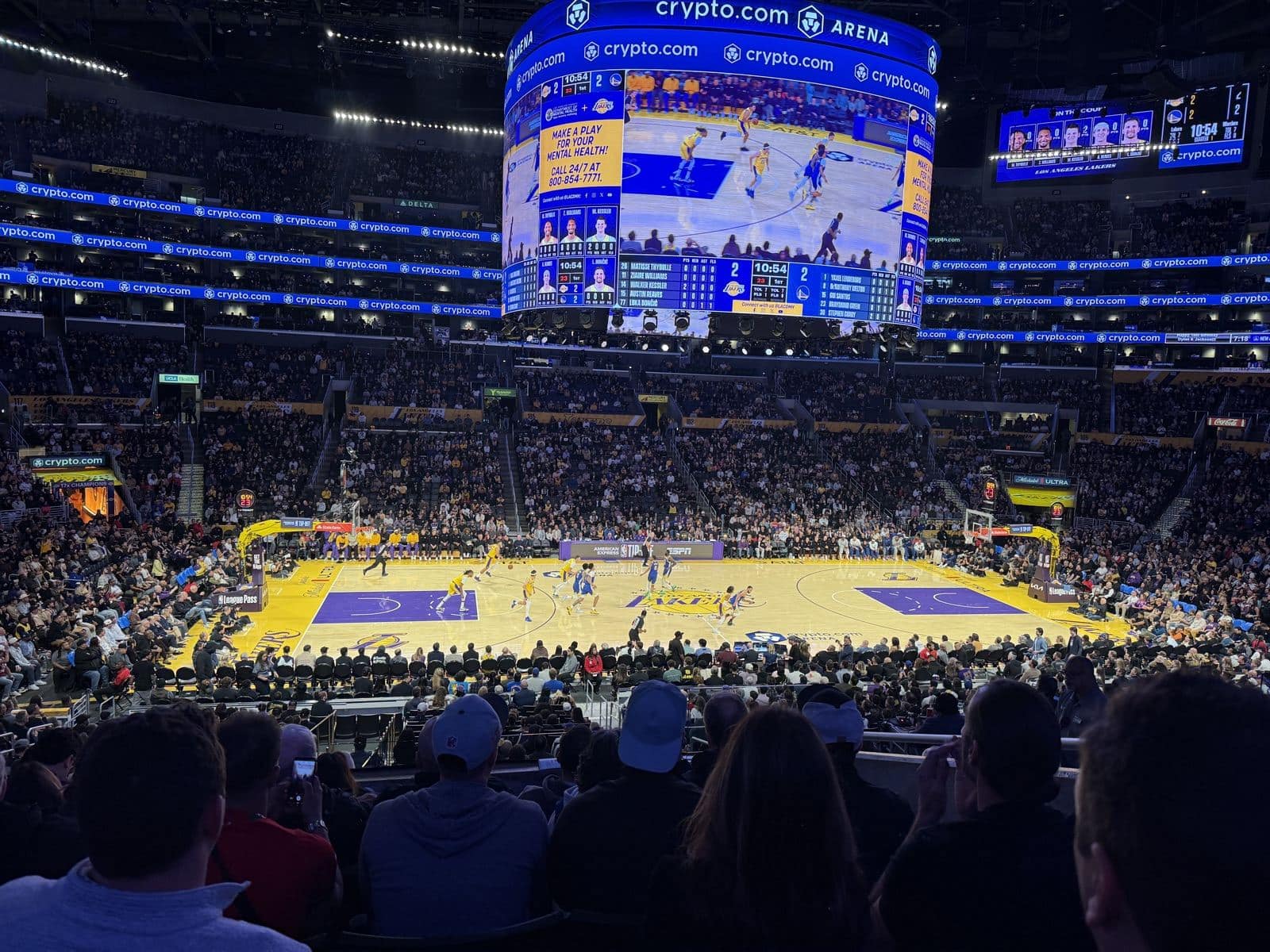 Wide view of the Lakers court and lower bowl at Crypto.com Arena with the Lakers in gold and the Warriors in blue
