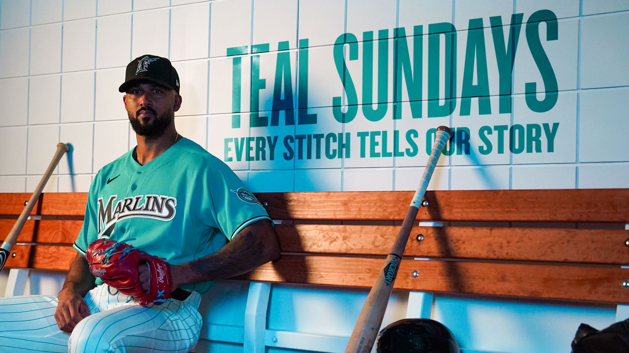 Miami Marlins player in teal Sundays jersey sitting in dugout