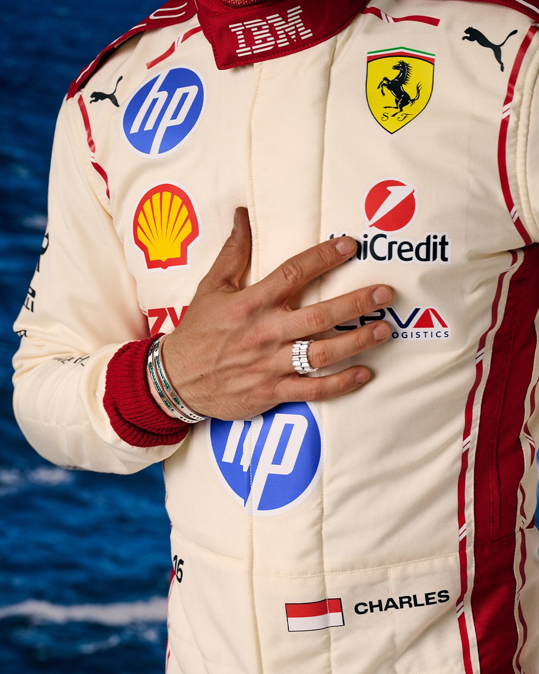 Charles Leclerc Ferrari F1 Monaco Grand Prix 2026 special home race suit alternate angle showing the white base with red sleeve stripes and the HP sponsor logo against the ocean backdrop