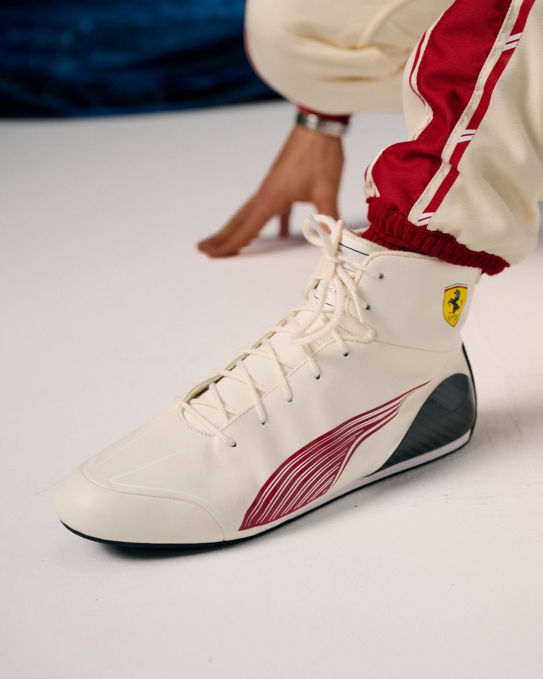 Charles Leclerc Ferrari F1 Monaco Grand Prix 2026 special home race suit detail shot showing the Ferrari prancing horse crest, the HP title sponsor mark, and the red trim running through the collar and chest of the white suit