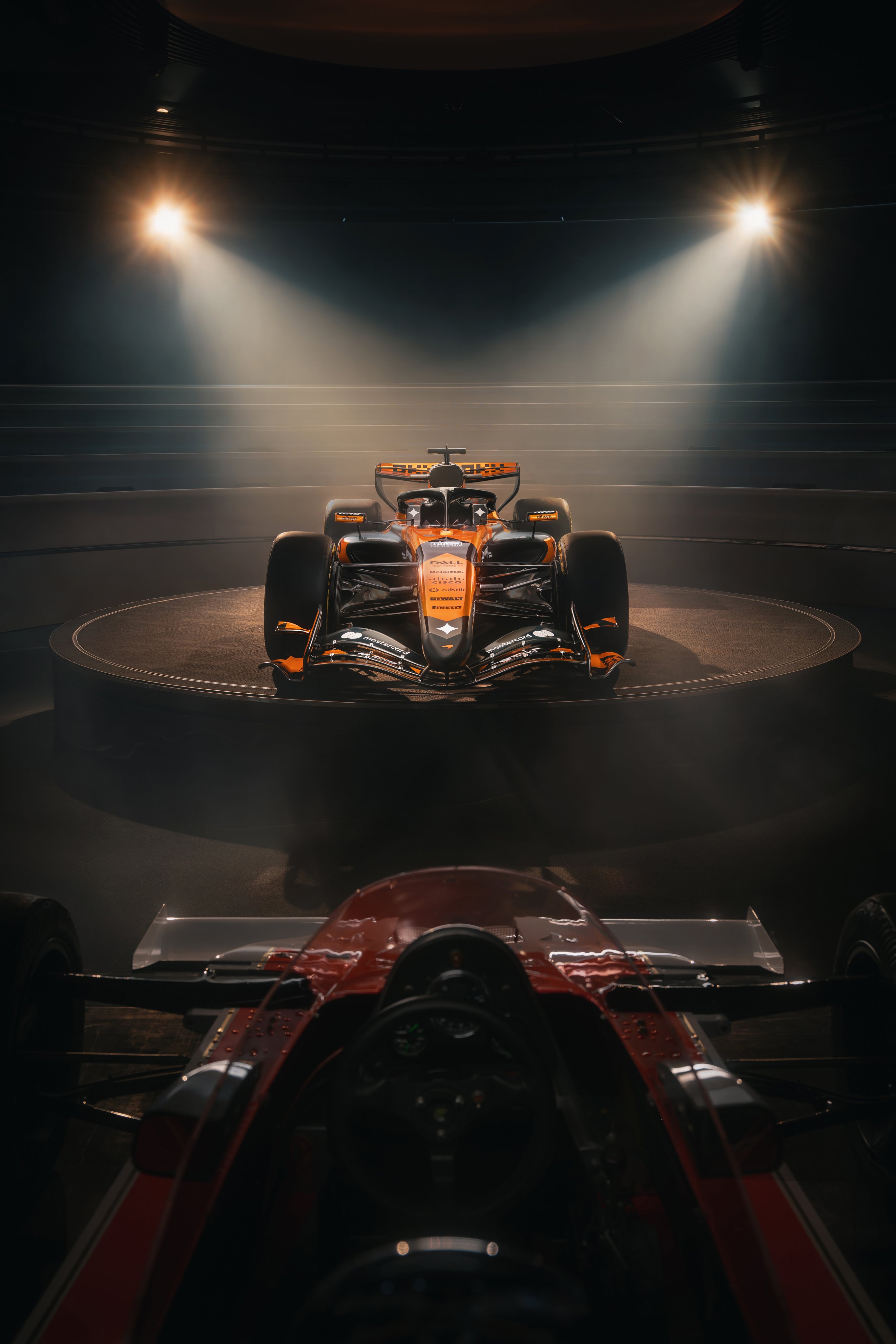 McLaren F1 Monaco Grand Prix 2026 special livery front-on staged shot of the MCL40 mounted in studio with dramatic overhead lighting and the orange and black retro paint scheme on display