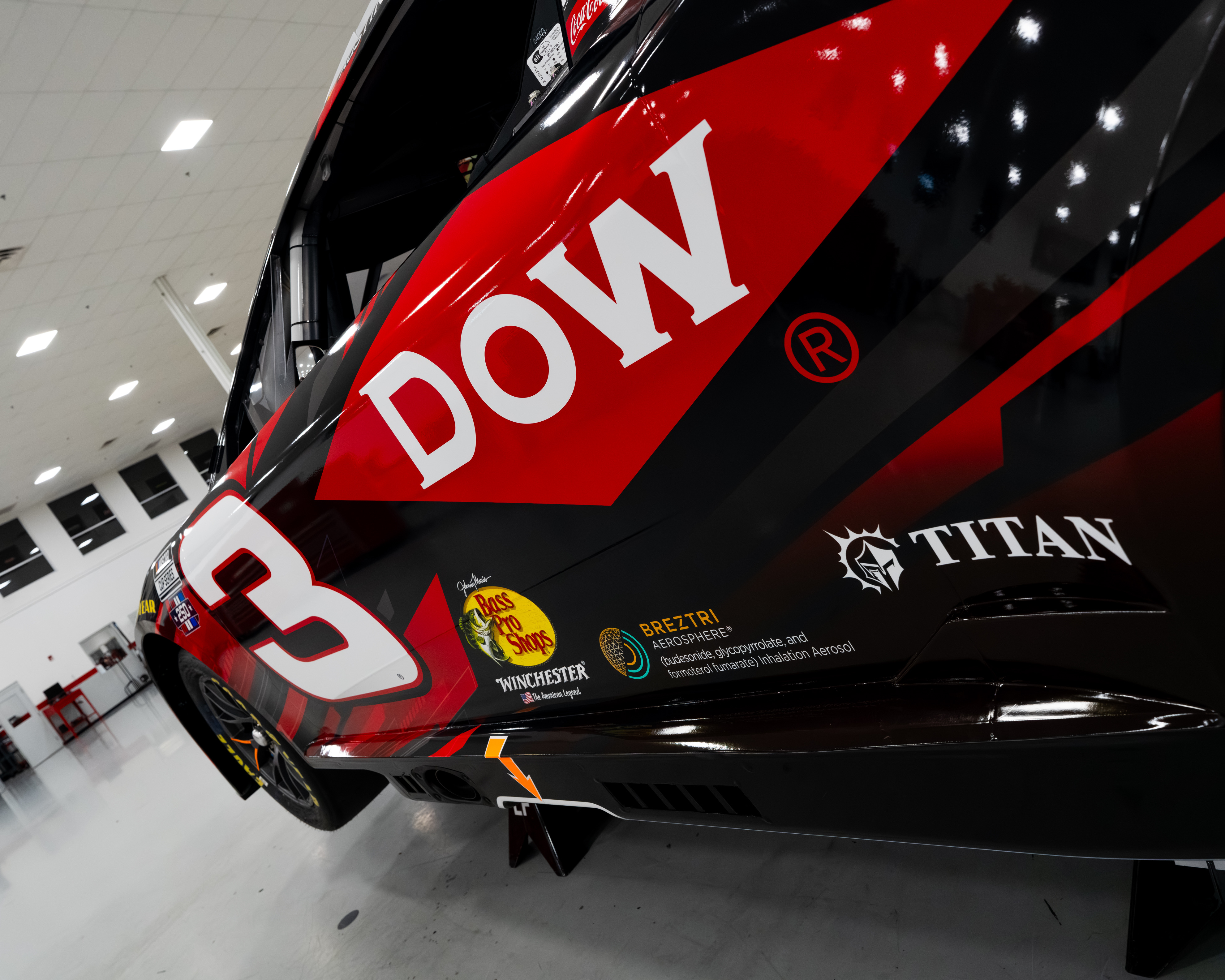 Closeup detail of the DOW primary sponsor wordmark on Austin Dillon's #3 Richard Childress Racing Chevrolet for the 2026 NASCAR Cup Series, the white block letters on the red panel design of the quarter panel