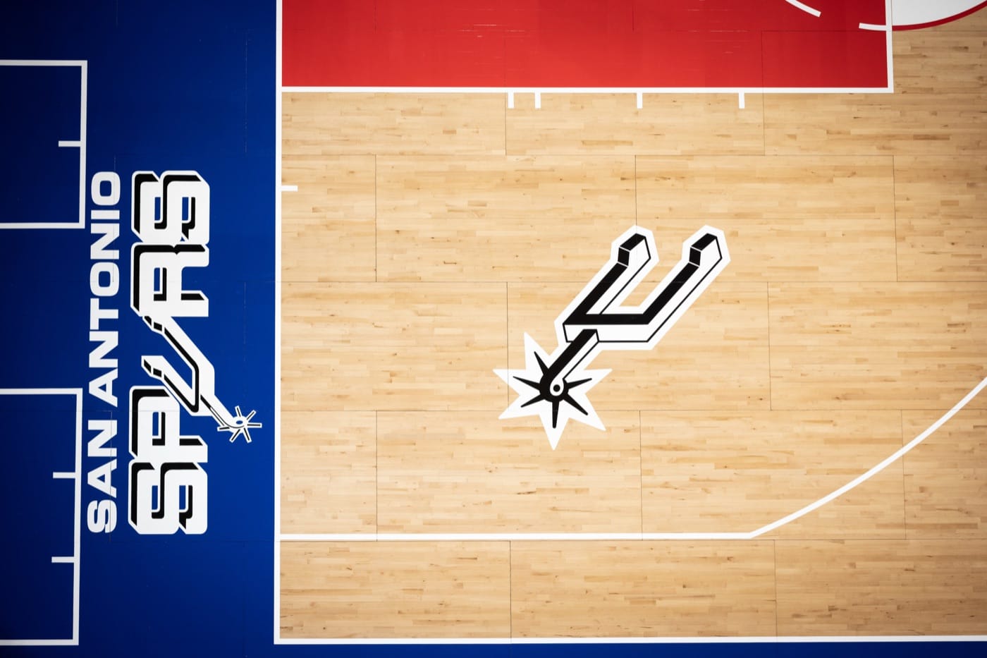 Spurs Classic Edition court baseline: SAN ANTONIO SPURS on the blue apron and the spur logo on the wood beside the red lane