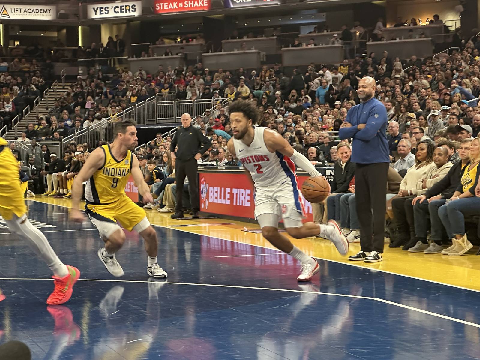 Pacers guard T. J. McConnell, in Indiana's gold INDIANA jersey with navy trim, defends Pistons guard Cade Cunningham at Gainbridge Fieldhouse on Nov. 29, 2024