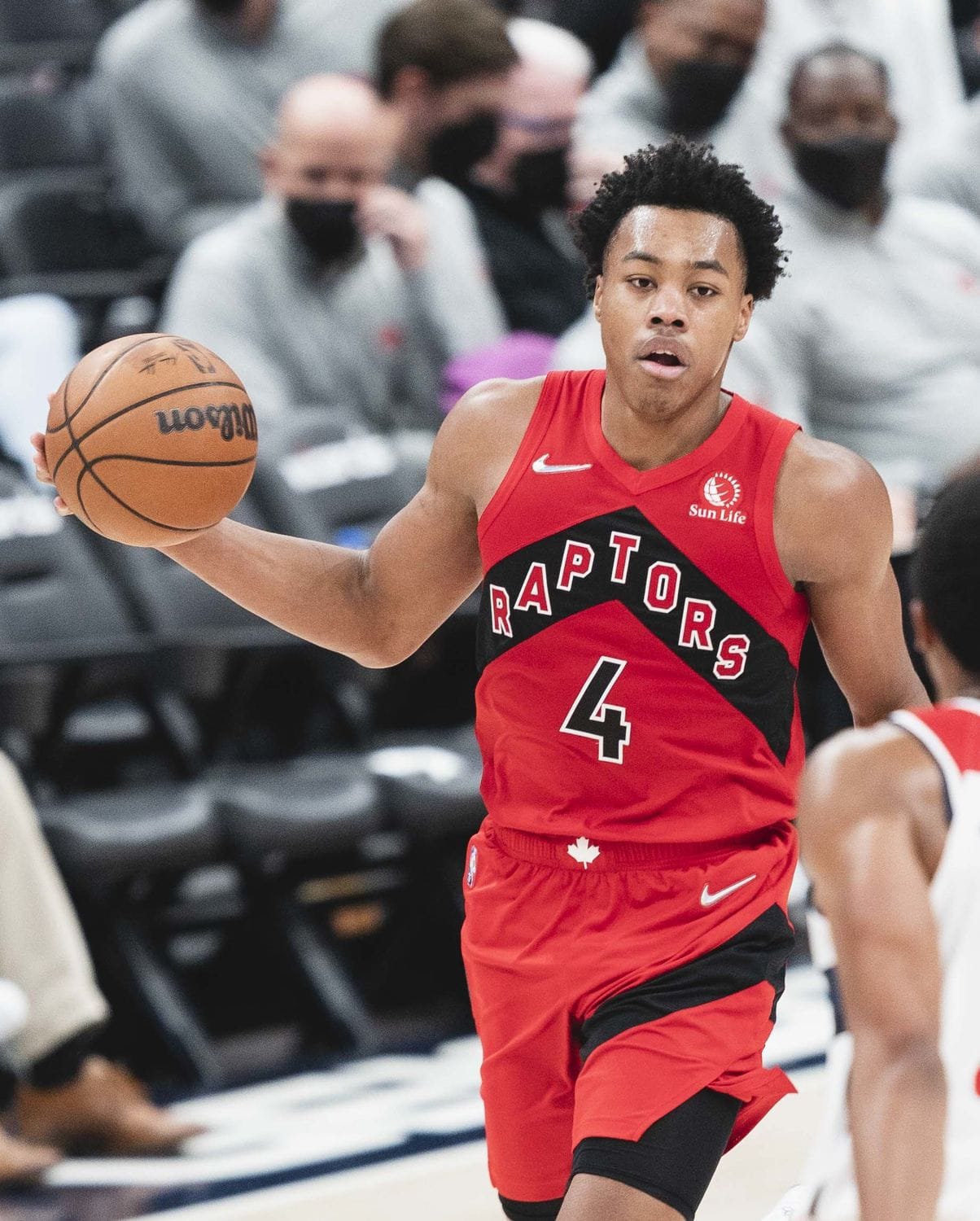 Raptors forward Scottie Barnes brings the ball up in Toronto's red Icon Edition jersey, with RAPTORS running down a black diagonal panel, against the Wizards at Capital One Arena on Oct. 12, 2021