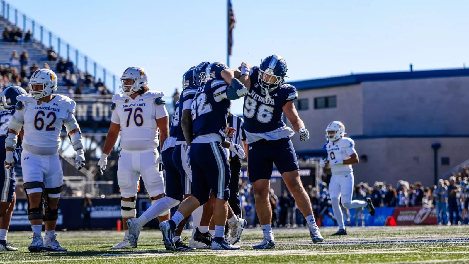 Nevada Wolf Pack defensive lineman No. 96 celebrating against San Jose State on October 24, 2026, wearing the navy helmet with the new Interlocked UN logo