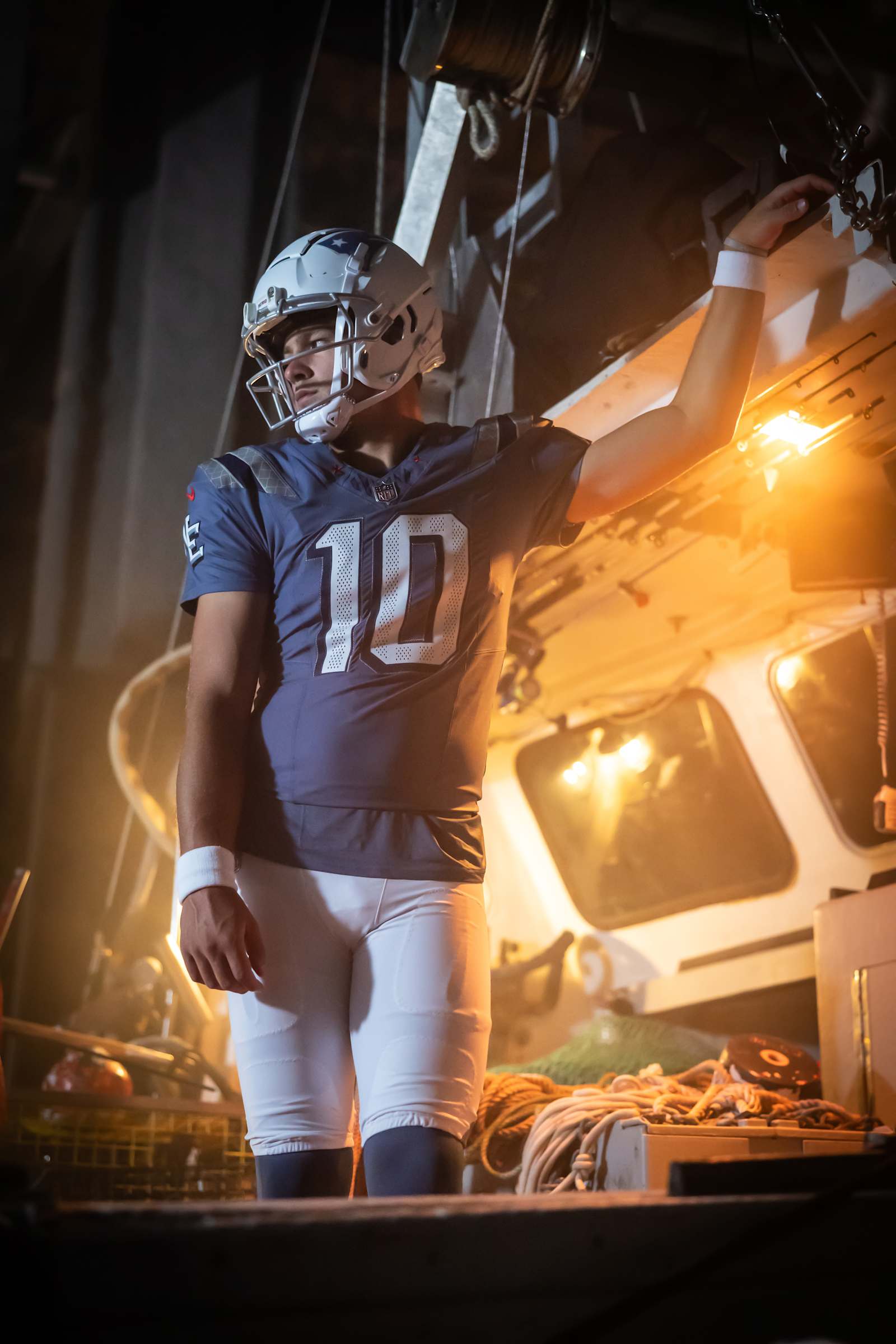 New England Patriots Nor'easter Rivalries uniform on Drake Maye, a weathered Storm Blue jersey with white numbers, textured shoulders and an NE sleeve mark, white pants, and a white helmet with a navy stripe and star