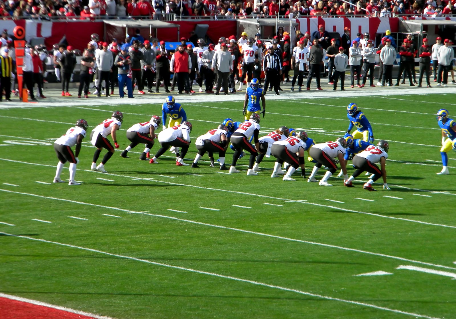 The Tampa Bay Buccaneers in white jerseys lined up against the Los Angeles Rams at Raymond James Stadium during a playoff game