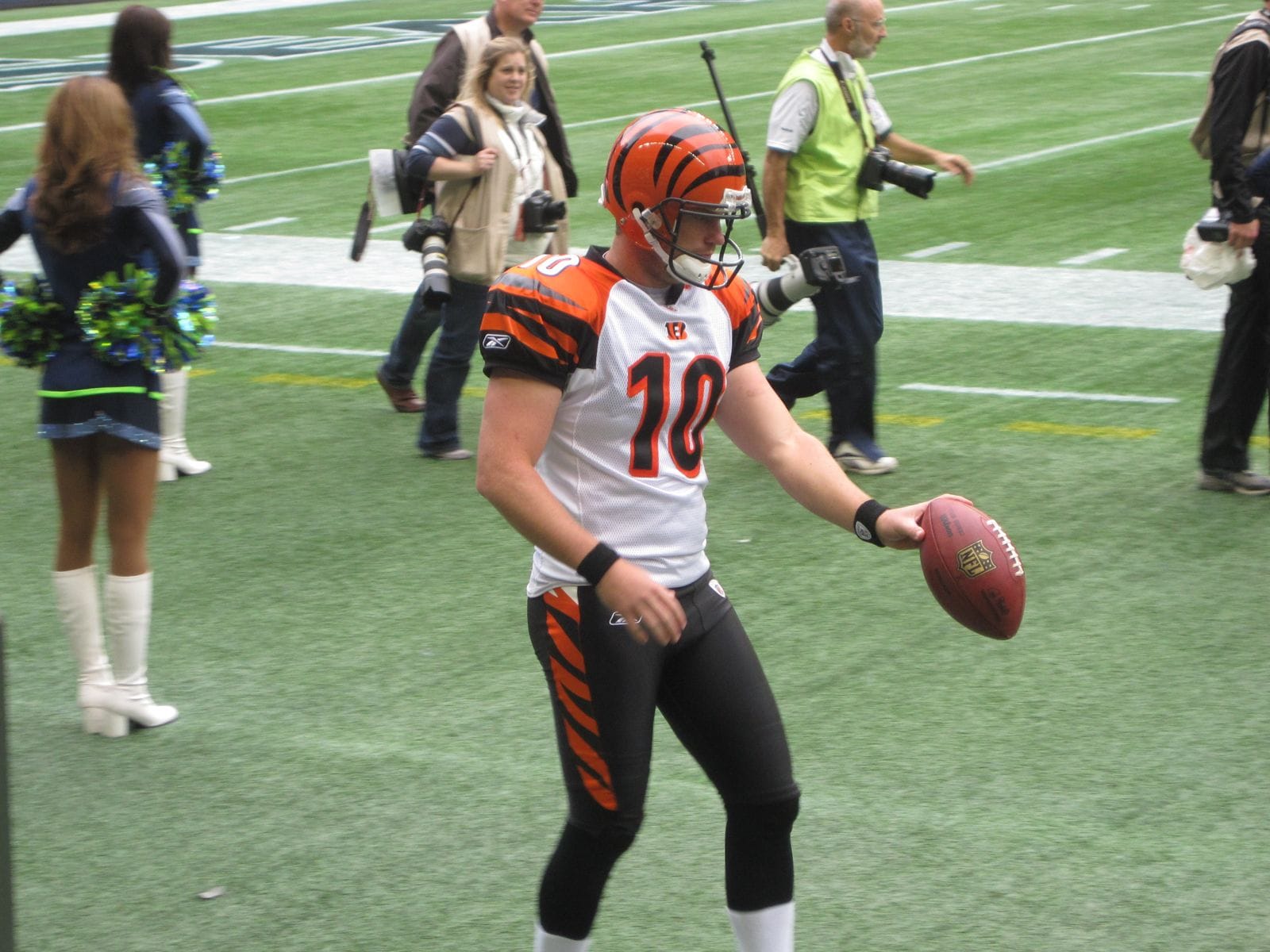 Bengals punter Kevin Huber on the sideline in Seattle in 2011, wearing the orange helmet with black tiger stripes and the white road jersey with tiger-striped sleeves