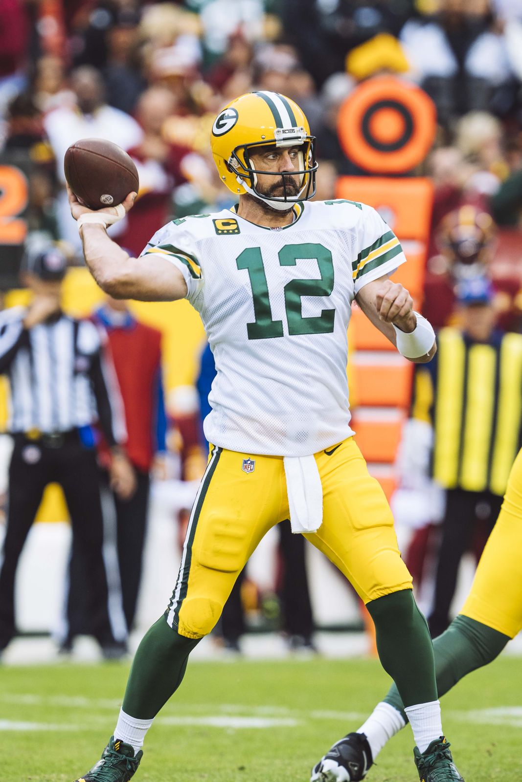 Packers quarterback Aaron Rodgers throwing a pass in the white road jersey, gold pants and gold helmet with the green and white G logo, at Washington in October 2022