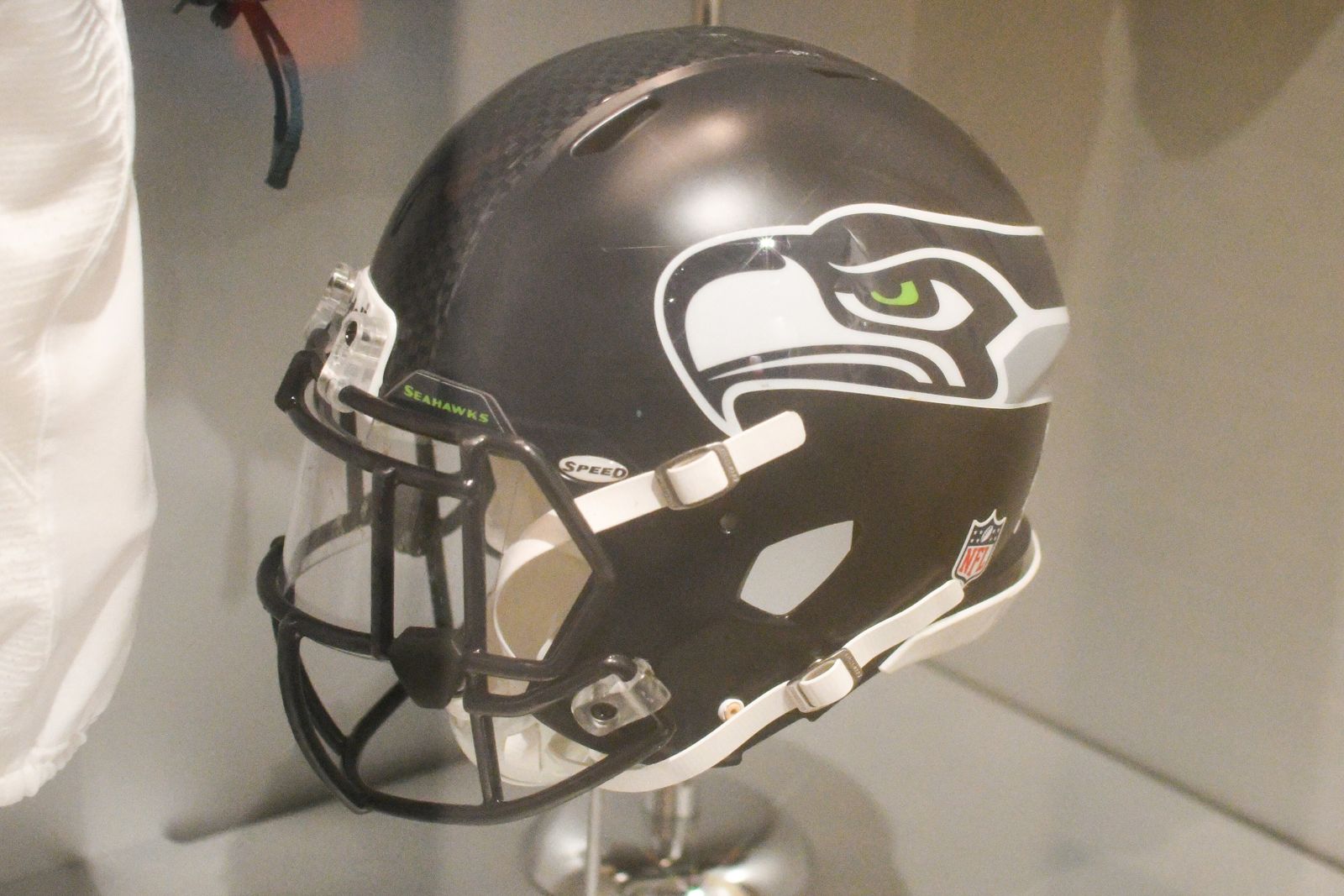 A navy Seattle Seahawks helmet with the gray and blue bird-head logo with a lime green eye, on display at the Pro Football Hall of Fame