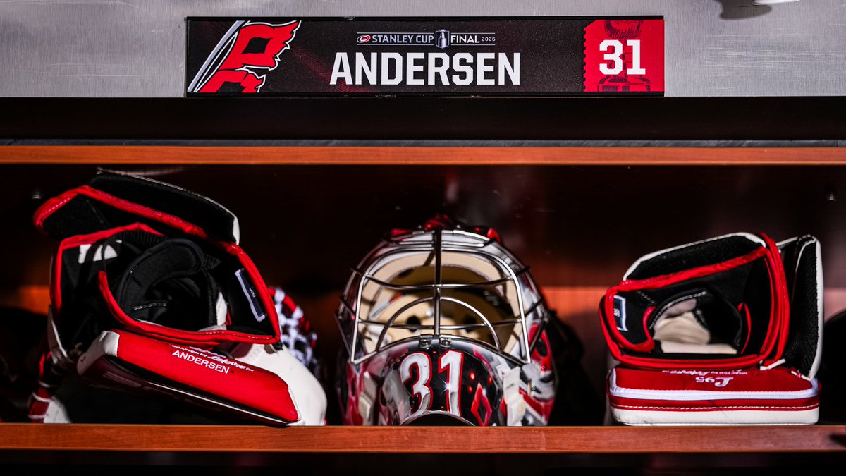 Frederik Andersen's Carolina Hurricanes Stanley Cup Final 2026 locker setup with a custom name plate at the top reading ANDERSEN 31 with STANLEY CUP FINAL 2026 wordmark and the Hurricanes flag logo, his goalie catcher glove with ANDERSEN stitching on the cuff on the left, his goalie mask with the number 31 prominent in white on red with Hurricanes red and black and white themed design in the center, and his goalie blocker pad with red white and black design on the right