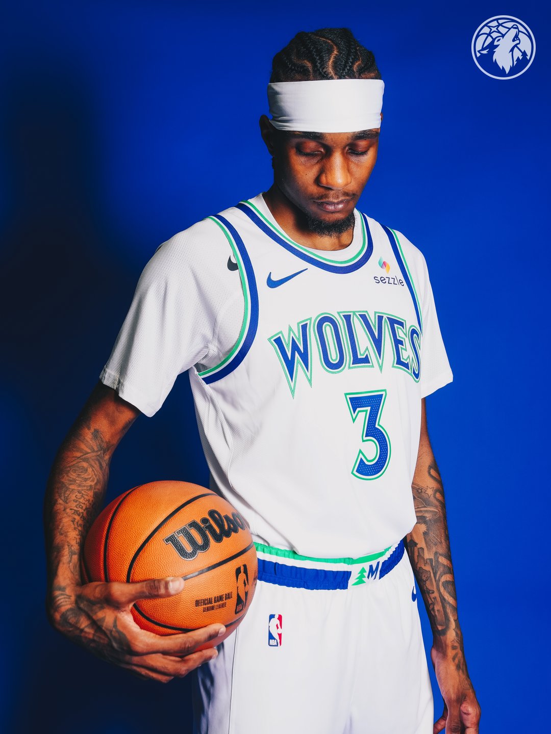 Minnesota Timberwolves new Association Edition white home jersey 2026-27 standing pose showing the WOLVES wordmark, the #3 chest number in blue with green outline, the matching white shorts with the green tree and Minnesota M monogram label on the waistband, and the green and blue piping at the short hem