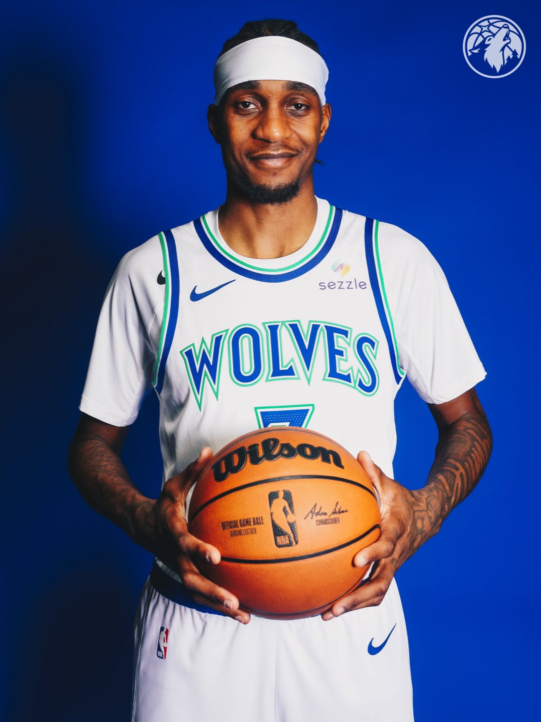 Minnesota Timberwolves new Association Edition white home jersey 2026-27 front view on player number 3 with the WOLVES wordmark in throwback blue and green outline, brighter blue and green color palette returning from the original 1989 expansion identity, and the Sezzle jersey patch on the chest