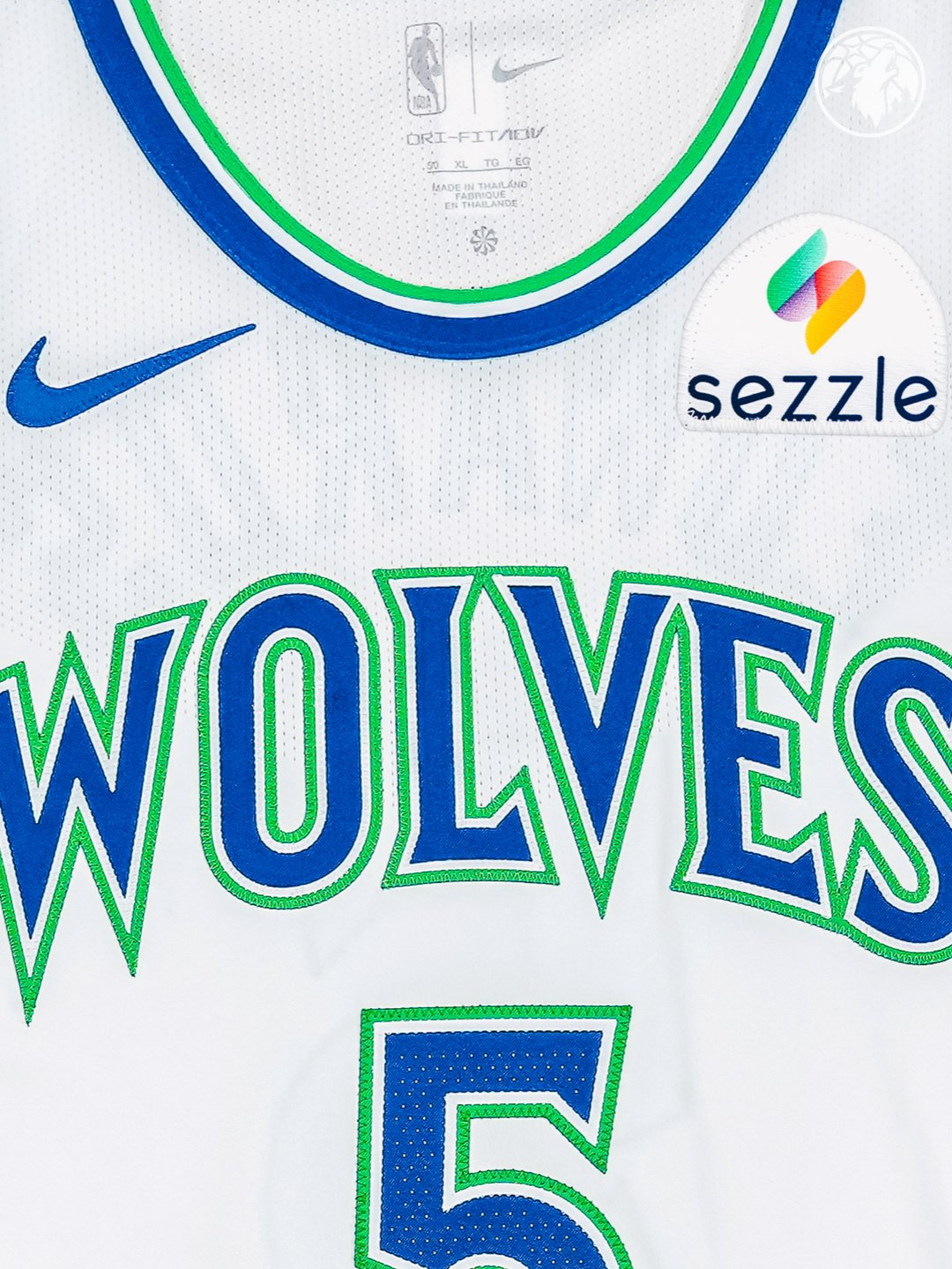 Minnesota Timberwolves new Association Edition white home jersey 2026-27 chest macro close-up of the WOLVES wordmark and number five typography showing the embroidered blue letterforms with the bright green outline detail and the throwback Mitchell and Ness style construction quality