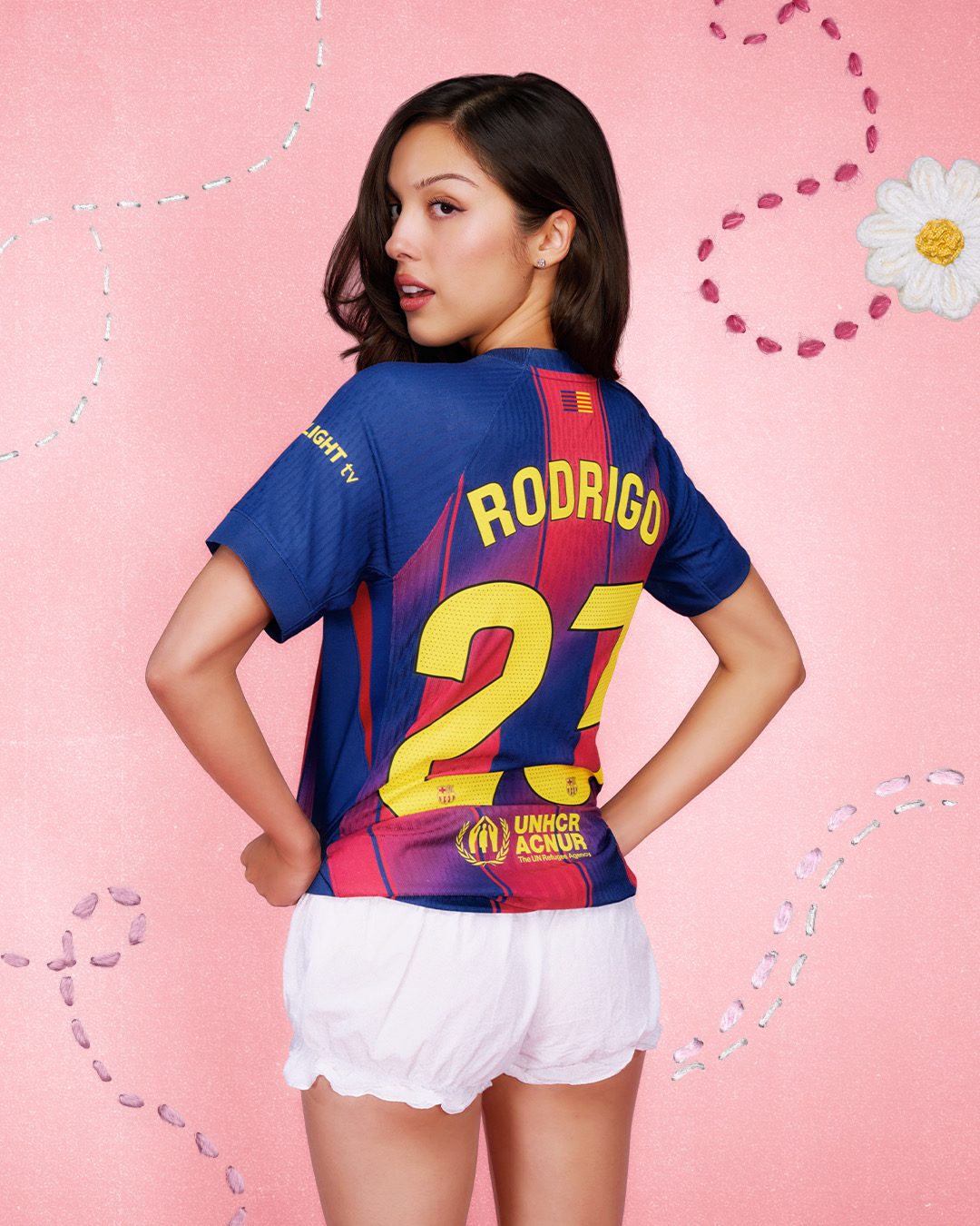 Olivia Rodrigo from behind wearing the personalized FC Barcelona El Clasico kit with RODRIGO 21 on the back of the Nike home jersey for the 2026 Spotify Camp Nou Real Madrid match