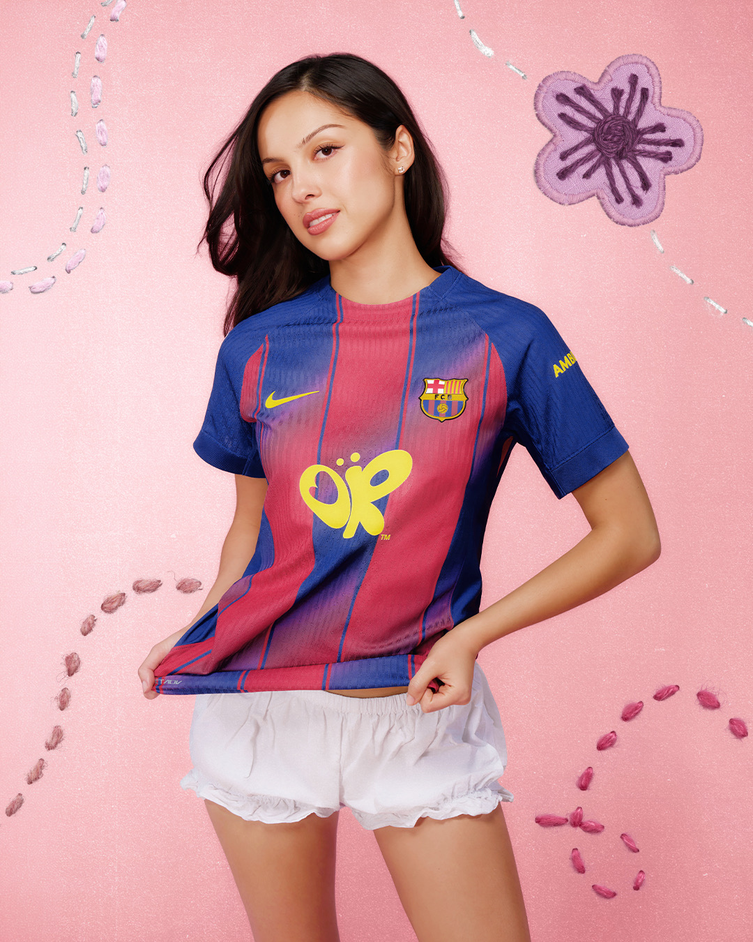 Olivia Rodrigo wearing the FC Barcelona El Clasico kit with the yellow butterfly logo on the chest for the 2026 Spotify Camp Nou Real Madrid match