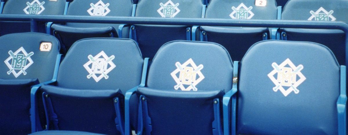 Navy seats at Milwaukee County Stadium printed with the 1994 to 1999 Brewers logo, an interlocking MB on crossed bats and a diamond