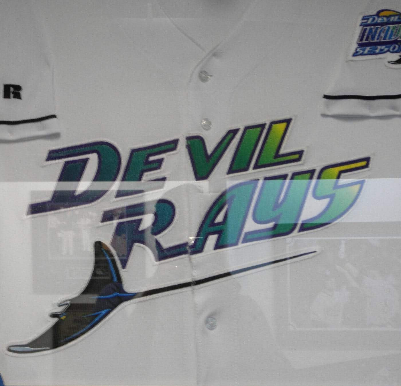A framed 1998 Tampa Bay Devil Rays home jersey with Devil Rays in a purple to green gradient over a devil ray