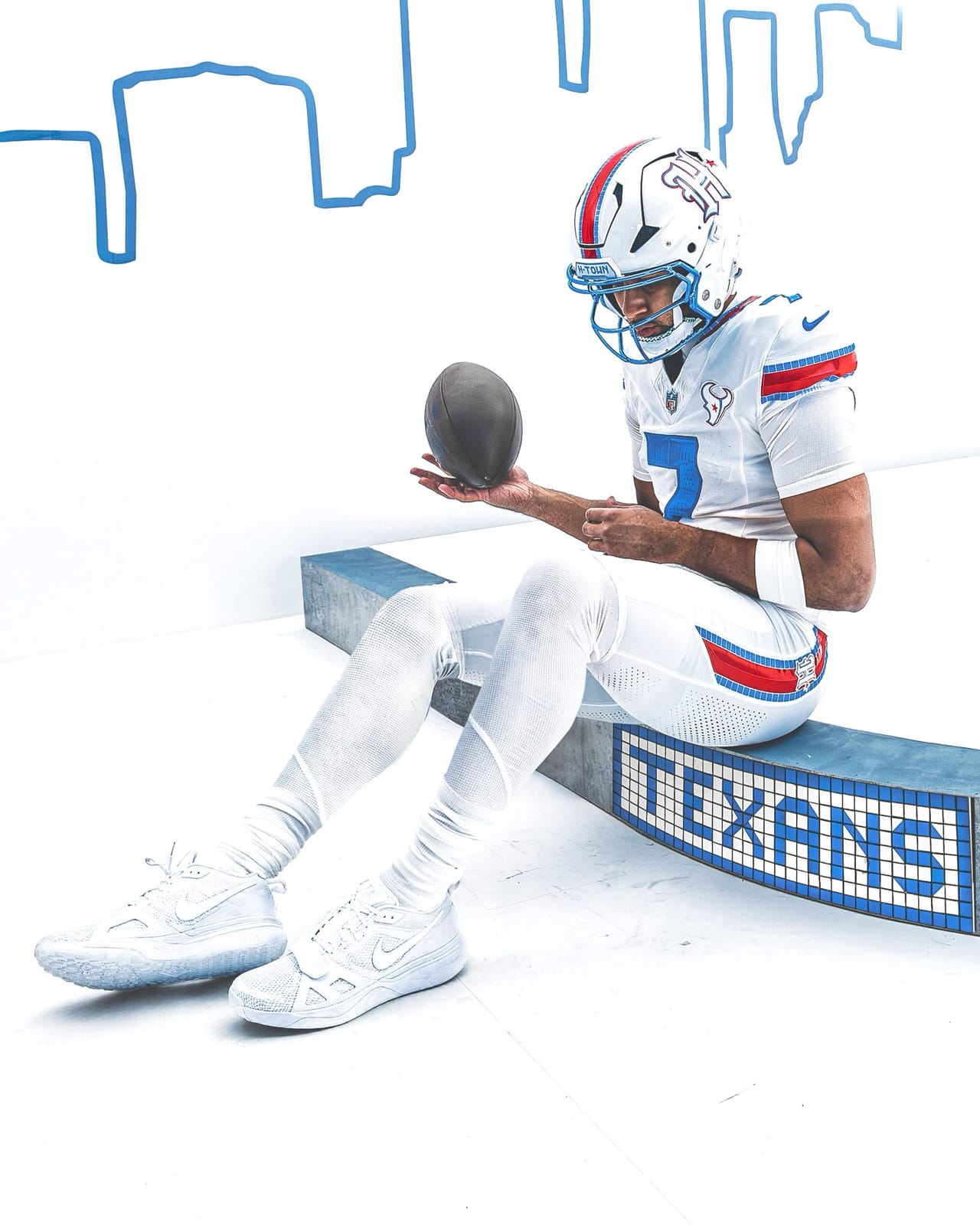 C.J. Stroud seated on a Houston tiled TEXANS bench in the full HOUSTON/US Rivalries uniform