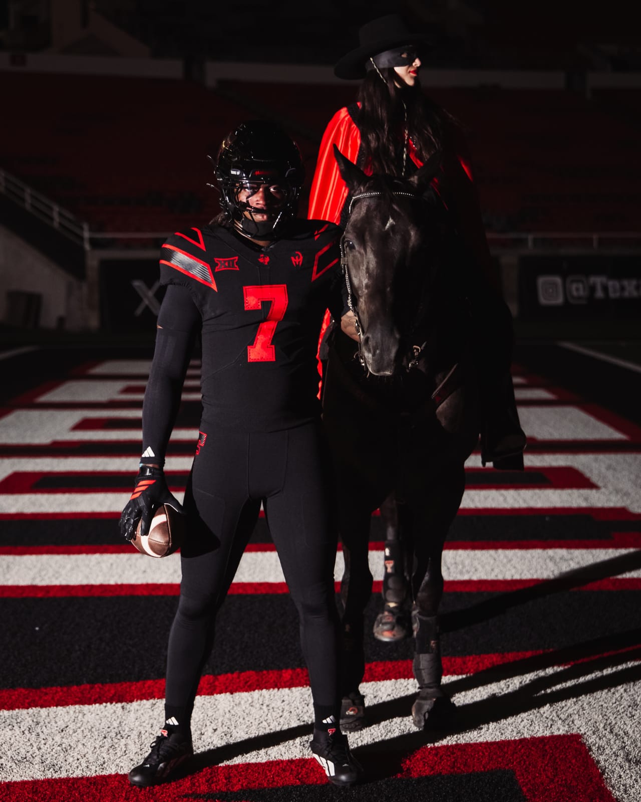 Texas Tech Let's Ride 2026 uniform, an all-black jersey and pants with red numbers and trim, worn next to the Masked Rider on horseback in the end zone