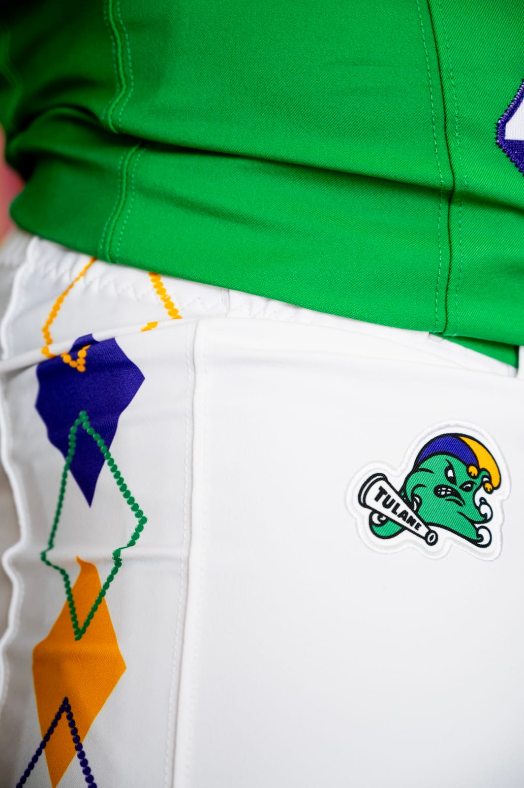 Tulane City Edition white pants with purple and gold argyle diamonds outlined in beads, and the Jester Angry Wave patch