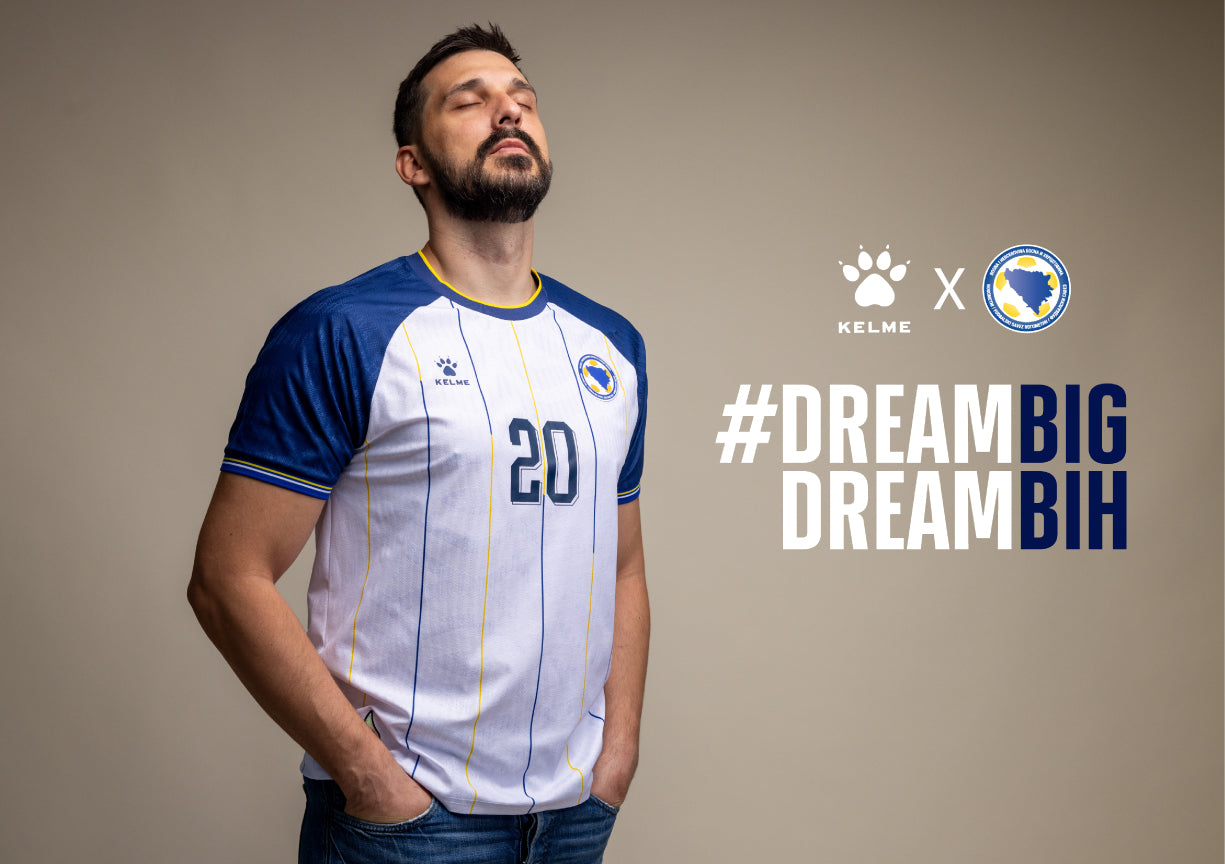 Bosnia and Herzegovina 2026 World Cup Kelme white away jersey with blue raglan sleeves and blue and yellow pinstripes, worn in the Group B match vs Switzerland