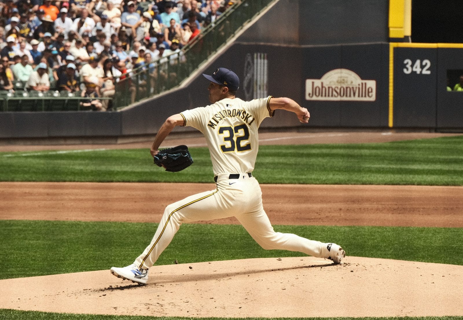 Brewers pitcher Jacob Misiorowski delivers a pitch in the cream home uniform with navy and gold trim and a navy cap at American Family Field