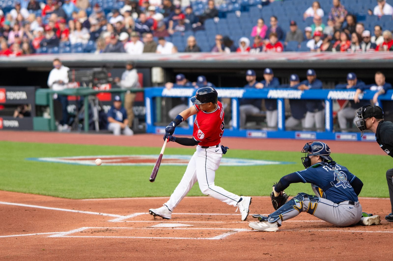 Guardians outfielder Steven Kwan swings in the red alternate while the Rays catcher wears the navy road alternate, April 2026 at Progressive Field
