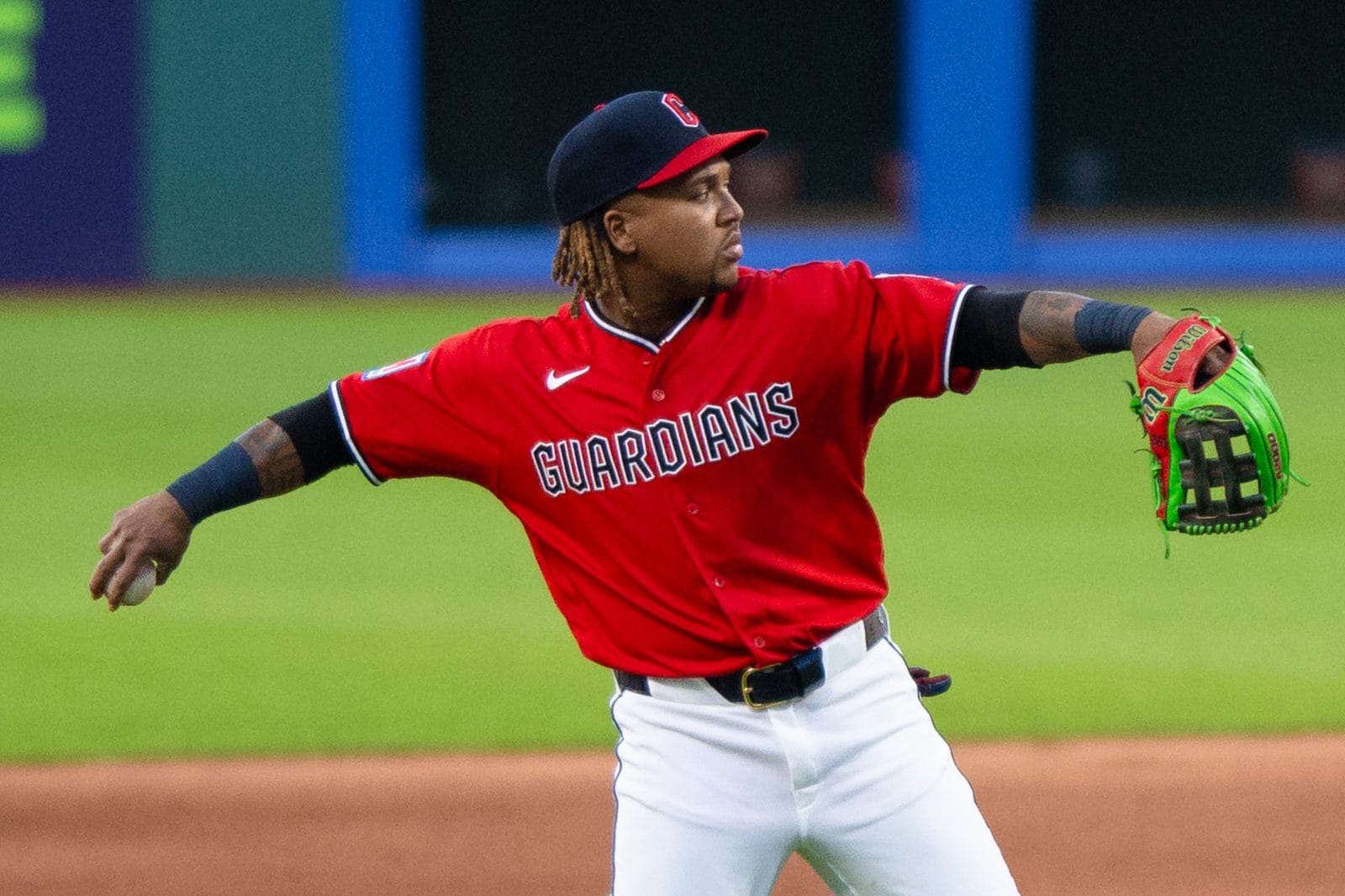 Guardians third baseman Jose Ramirez throwing in the red Guardians alternate jersey with white pants and a navy cap at Progressive Field